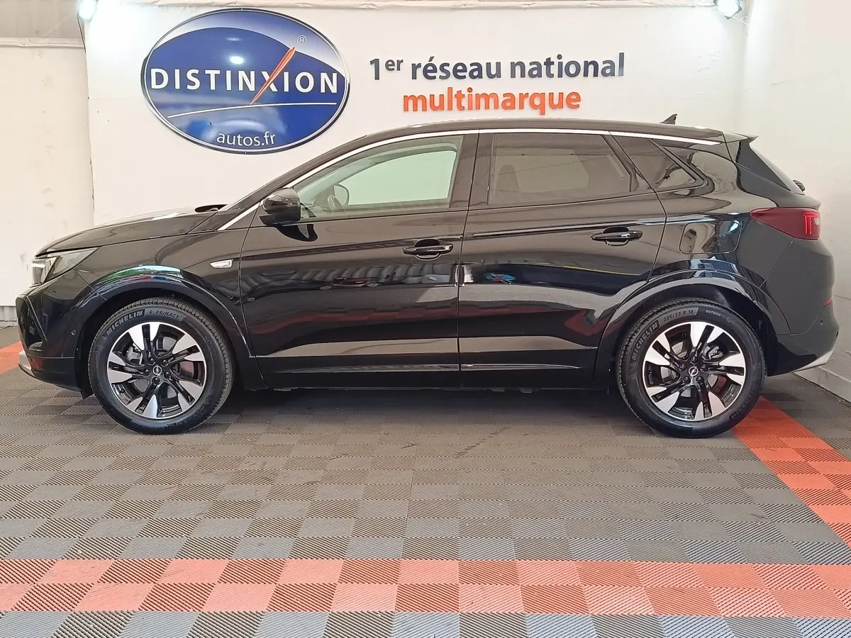 Profil droit d’un Opel Grandland hybride rechargeable noir 2023, avec jantes alliage bicolores et vitres teintées.