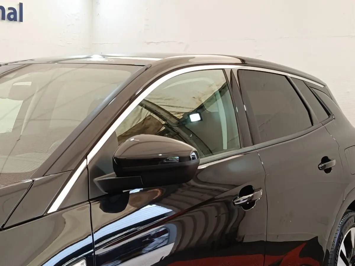 Vue latérale gauche d’un Opel Grandland hybride rechargeable noir brillant avec rétroviseur et poignées de porte visibles.