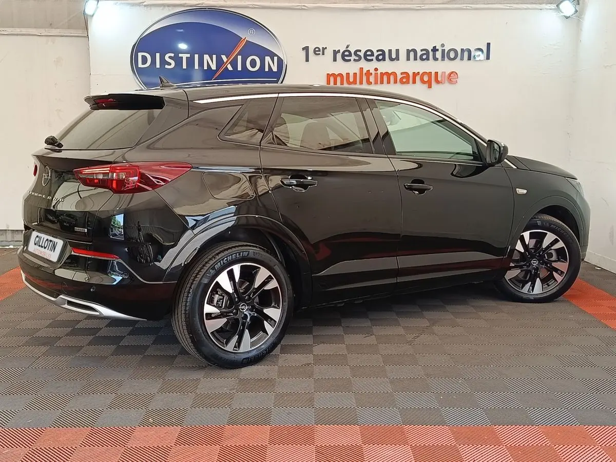 Opel Grandland hybride noir en profil droit, avec jantes alliage bicolores et feux arrière LED visibles.