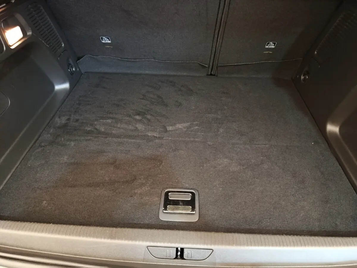 Vue plongeante sur le coffre spacieux et noir de l’Opel Grandland Hybride 225 ch, avec plancher plat et poignée centrale.