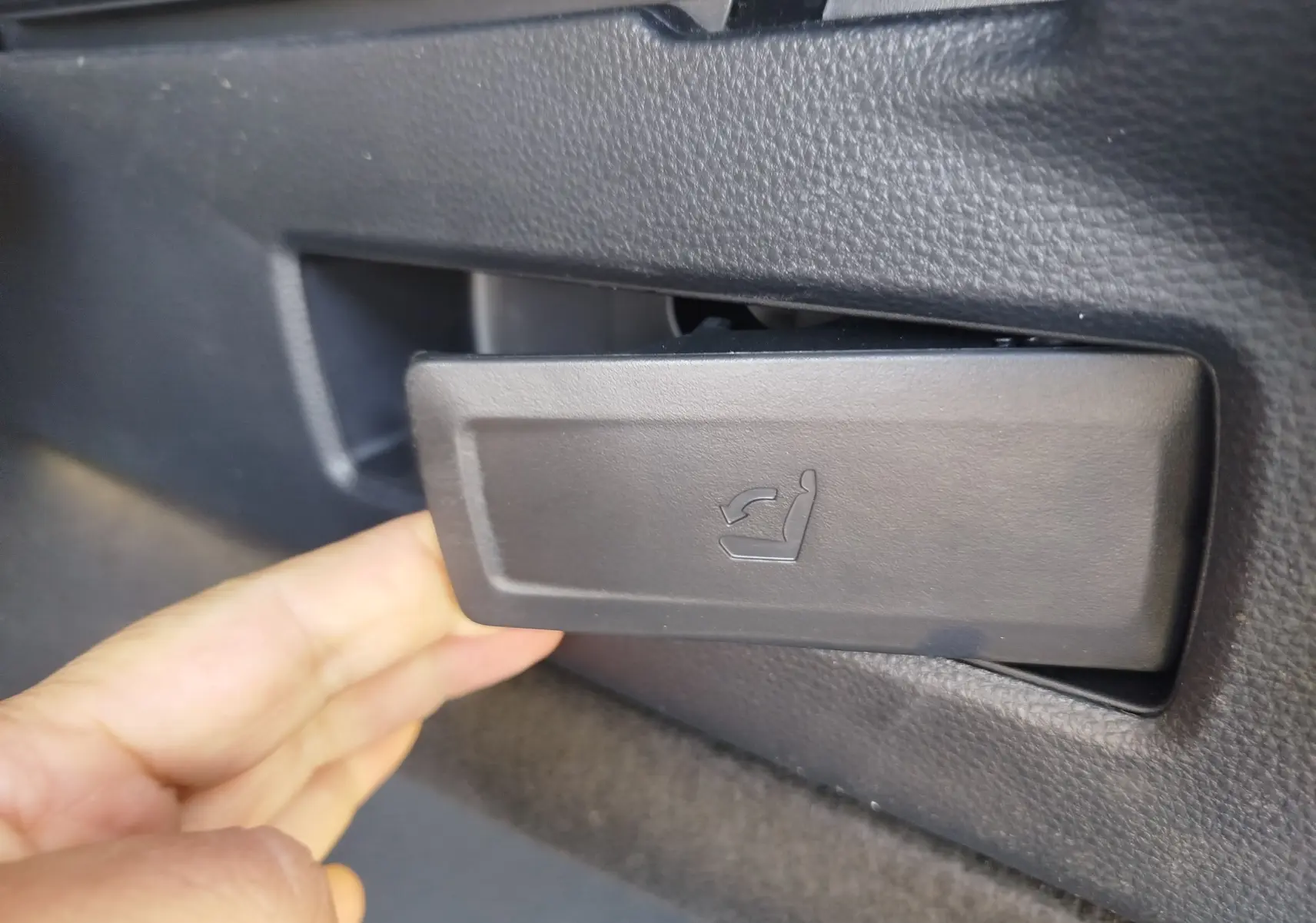 Gros plan sur la commande d'inclinaison du siège côté gauche dans une Toyota Corolla Touring Sport gris Atlas 2026.