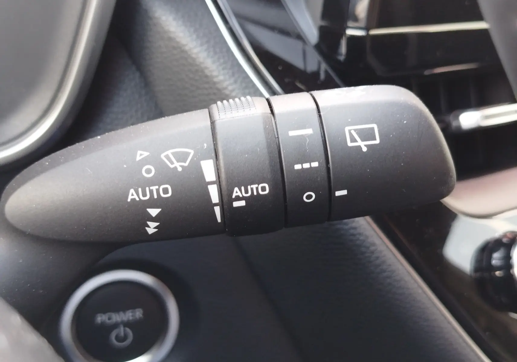Gros plan sur la commande d’essuie-glace noire à l’intérieur de la Toyota Corolla Touring Sport gris Atlas 2026.