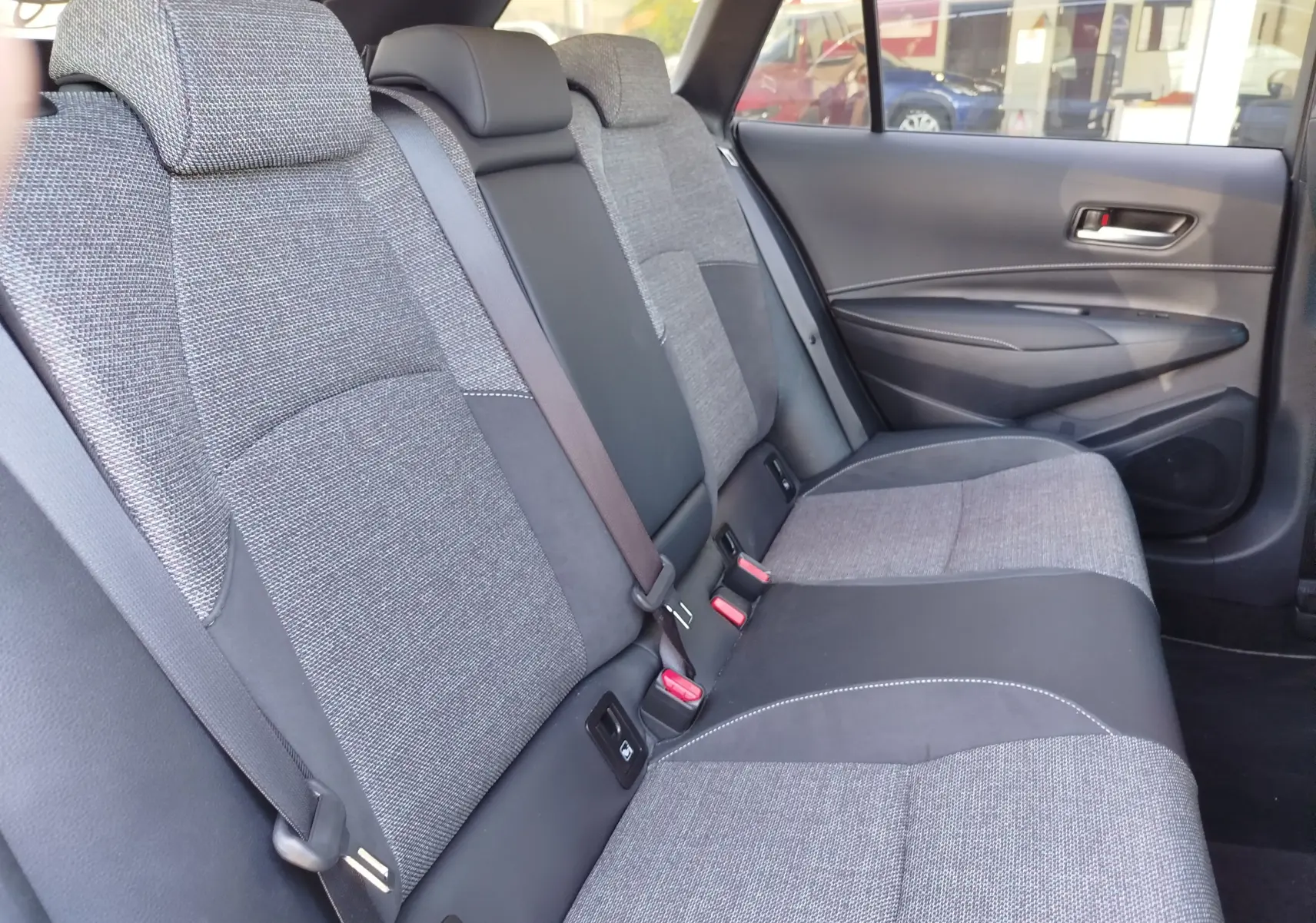 Vue intérieure côté droit des sièges arrière en tissu gris et noir de la Toyota Corolla Touring Sport 2026.