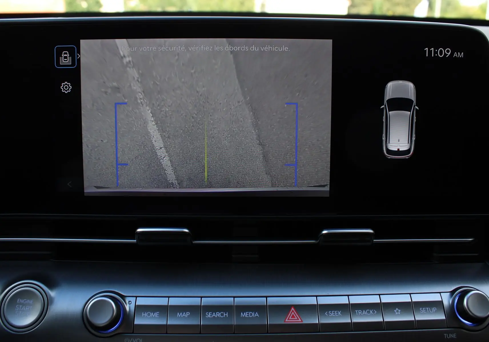 Vue intérieure du tableau de bord du Hyundai Kona 2024, écran affichant la caméra de recul avec vue sur le sol.