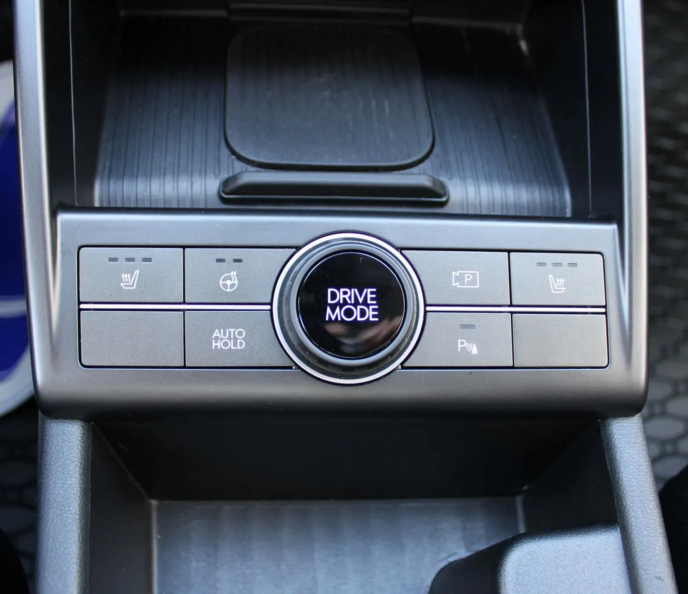 Gros plan sur la console centrale du Hyundai Kona 2024, montrant le bouton rotatif Drive Mode et commandes de sièges chauffants.