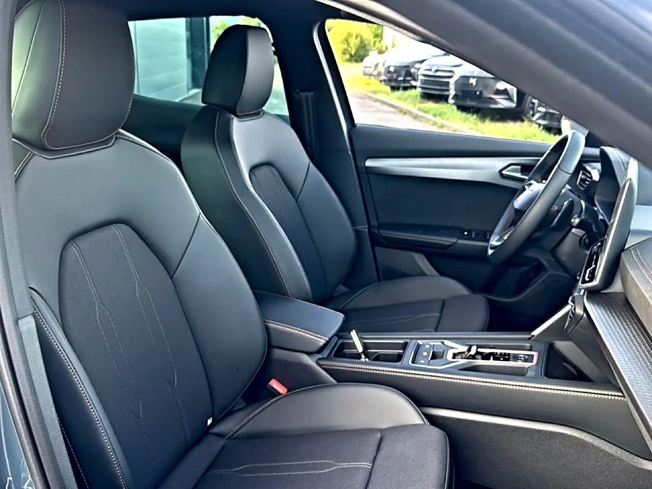 Vue intérieure côté conducteur du CUPRA Formentor 2026, sièges sport noirs avec surpiqûres contrastées et console centrale moderne.
