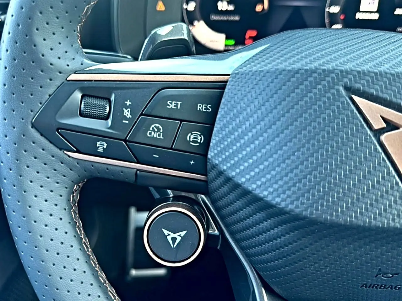 Gros plan sur le volant cuir perforé de la CUPRA Formentor 2026 avec commandes multifonctions et logo distinctif.