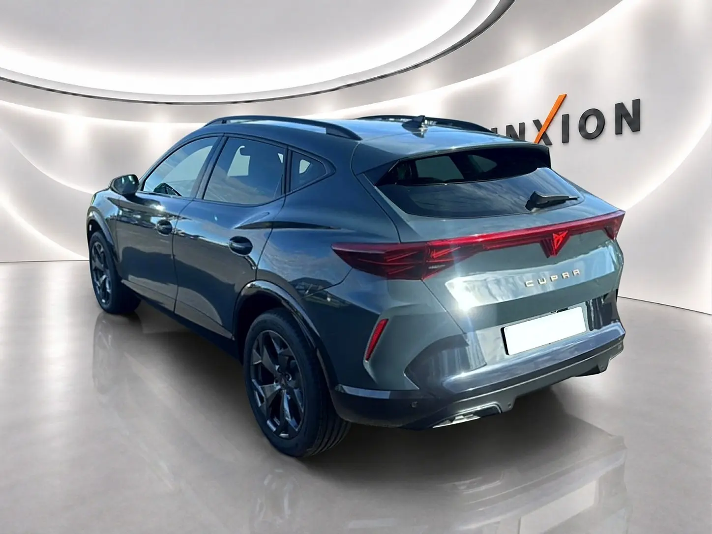 Vue 3/4 arrière droite d'un CUPRA Formentor 1.5 etsi hybrid bleu fjord avec feux arrière LED et jantes noires.