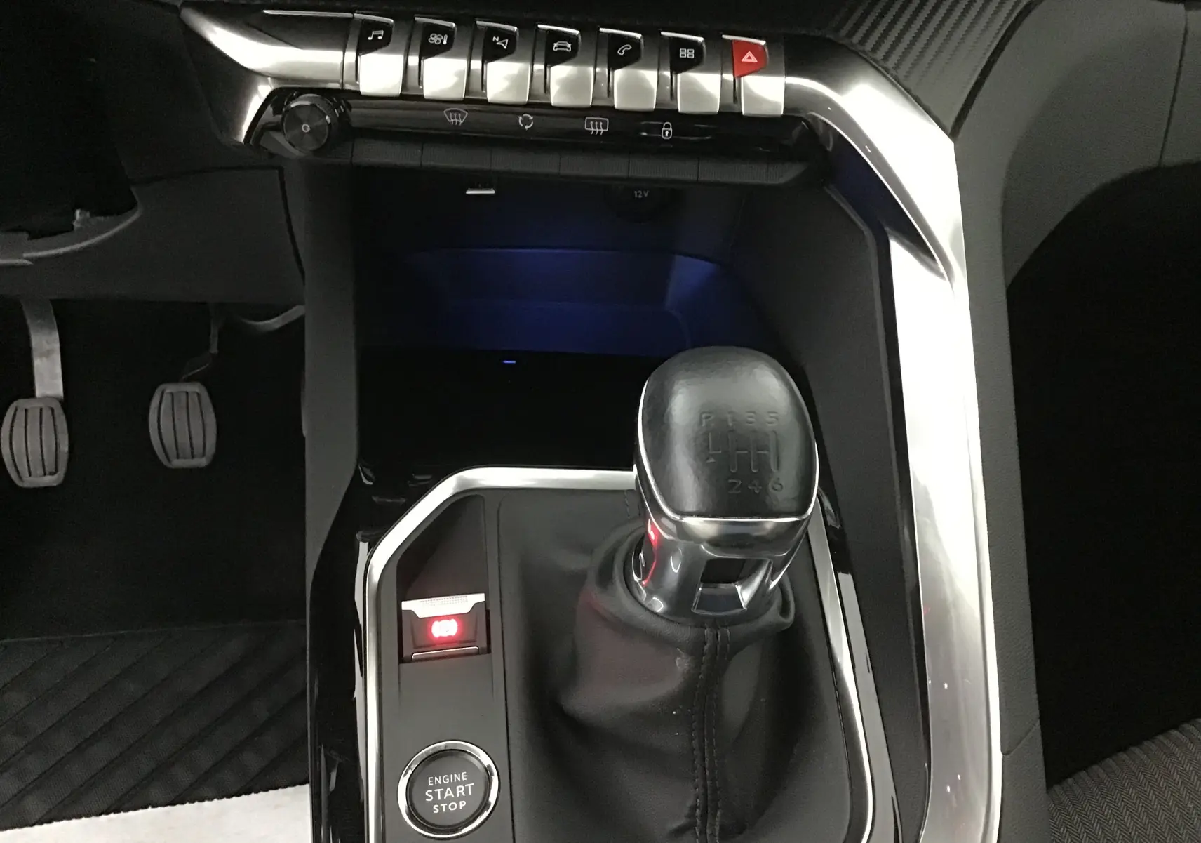 Gros plan sur la console centrale du Peugeot 5008 blanc nacré 2021, montrant le levier de vitesse manuel et les commandes éclairées.