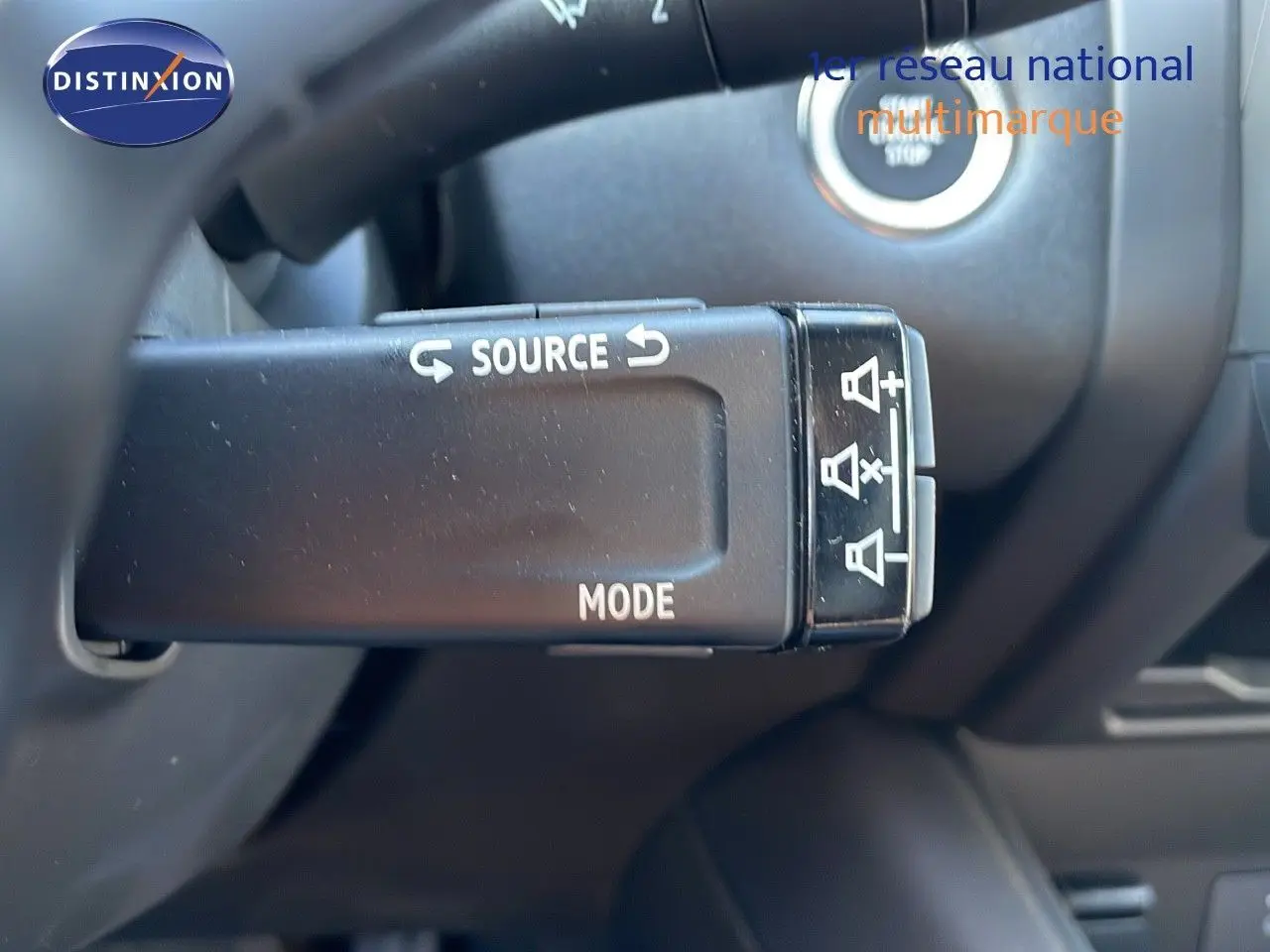 Commande au volant avec boutons source et mode du Renault Captur E-Tech hybride 2025, intérieur noir.
