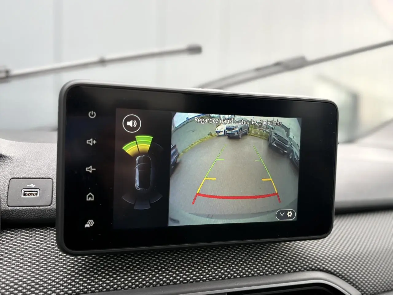 Écran tactile intérieur montrant la caméra de recul et l’aide au stationnement du Dacia Jogger Kaki Lichen.