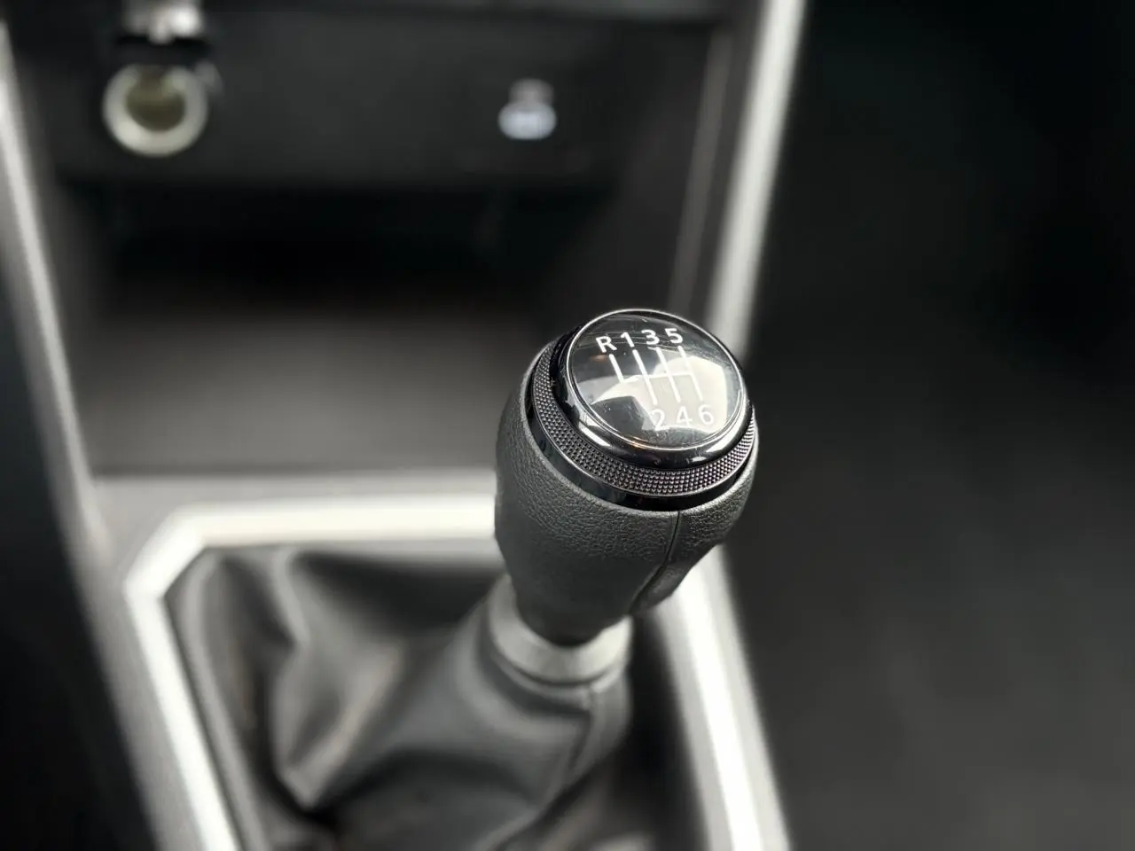 Gros plan sur le levier de vitesses manuel noir du Dacia Jogger 2025, avec indication des six rapports et marche arrière.