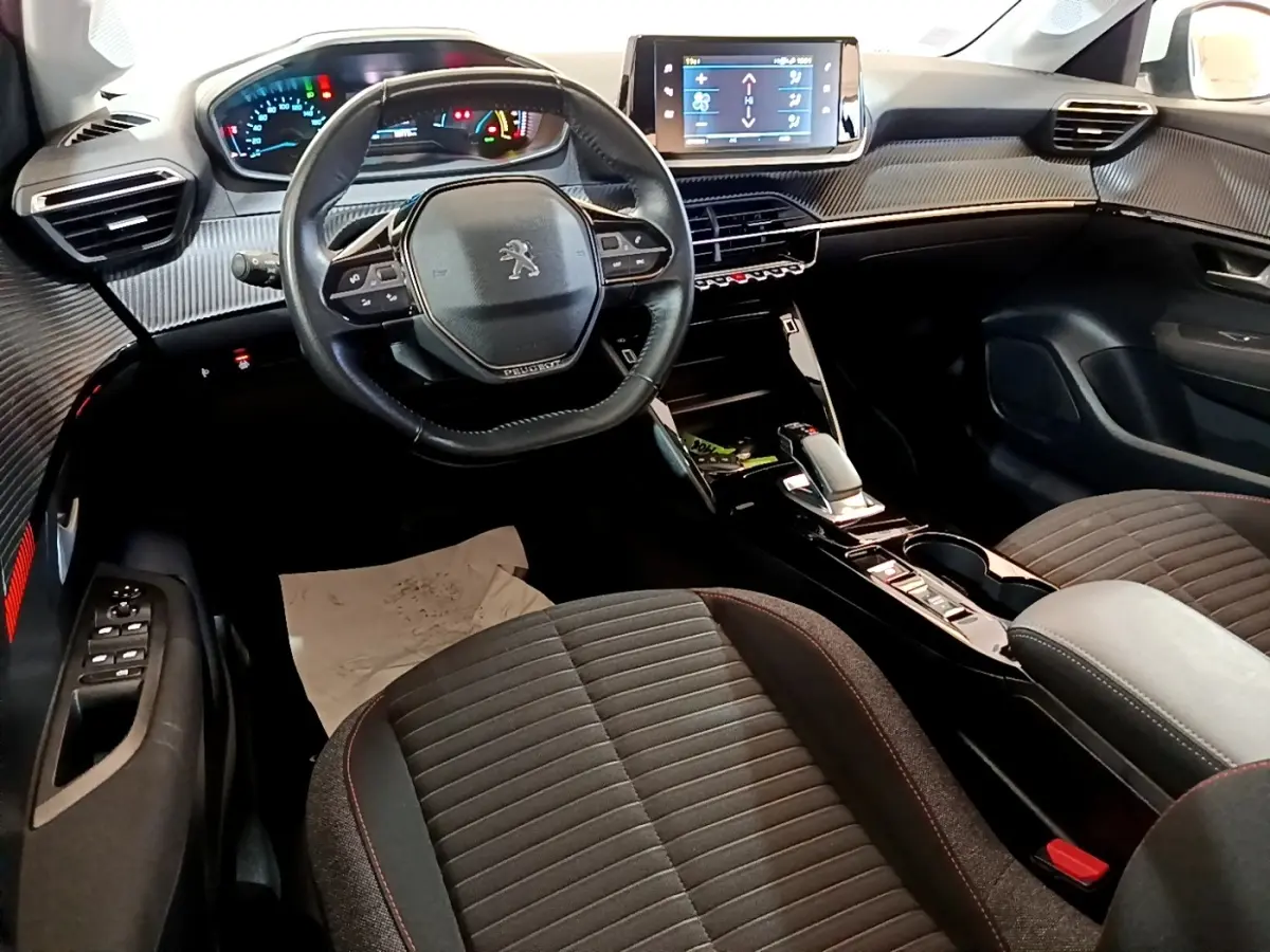 Vue intérieure avant de la Peugeot 208 Electrique Active Business 2021, tableau de bord avec écran tactile et volant cuir noir.