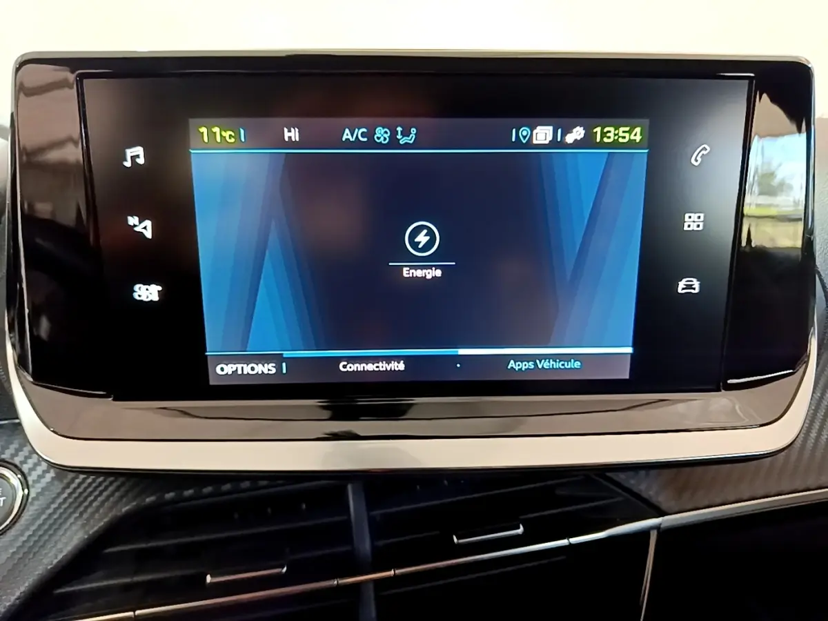 Écran tactile central affichant le menu énergie dans l’habitacle du Peugeot 208 électrique blanc, vue rapprochée.