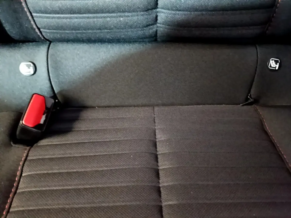 Gros plan sur la banquette arrière noire avec ceinture rouge et fixations Isofix d'une Peugeot 208 Electrique Active Business.