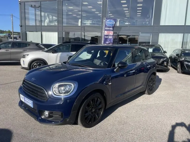Vue 3/4 avant droite d'une MINI Countryman Cooper D 2018 bleu avec jantes noires, stationnée devant un showroom.