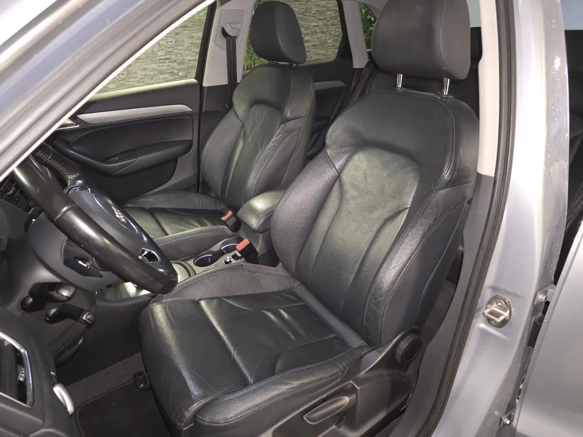 Vue intérieure côté conducteur de l'Audi Q3 2016 avec sièges cuir Nappa noirs et accoudoir central gris.