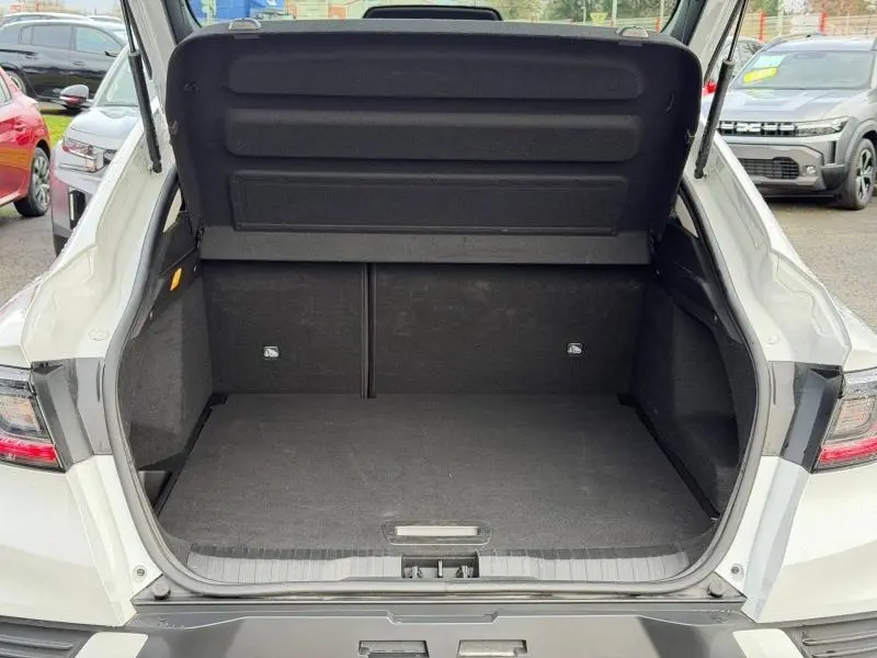 Coffre ouvert vu de l'arrière d'un Renault Arkana blanc 2025, montrant un espace de chargement spacieux et propre.
