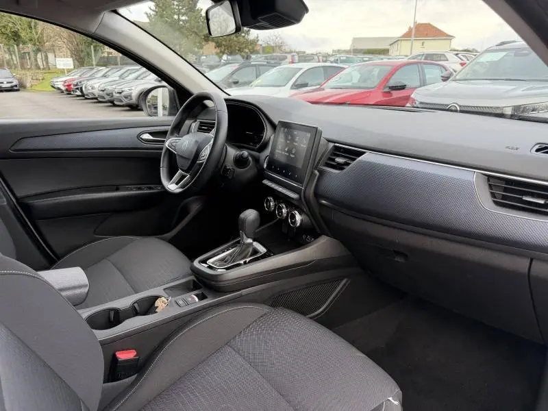 Intérieur du Renault Arkana 2025 vu côté conducteur, tableau de bord noir avec écran tactile et levier de boîte automatique.