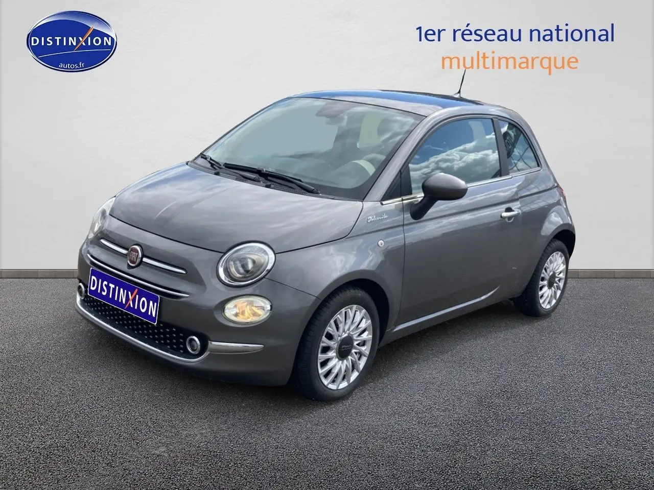 Fiat 500 gris vue 3/4 avant droit, avec jantes alu et toit panoramique en verre visible.