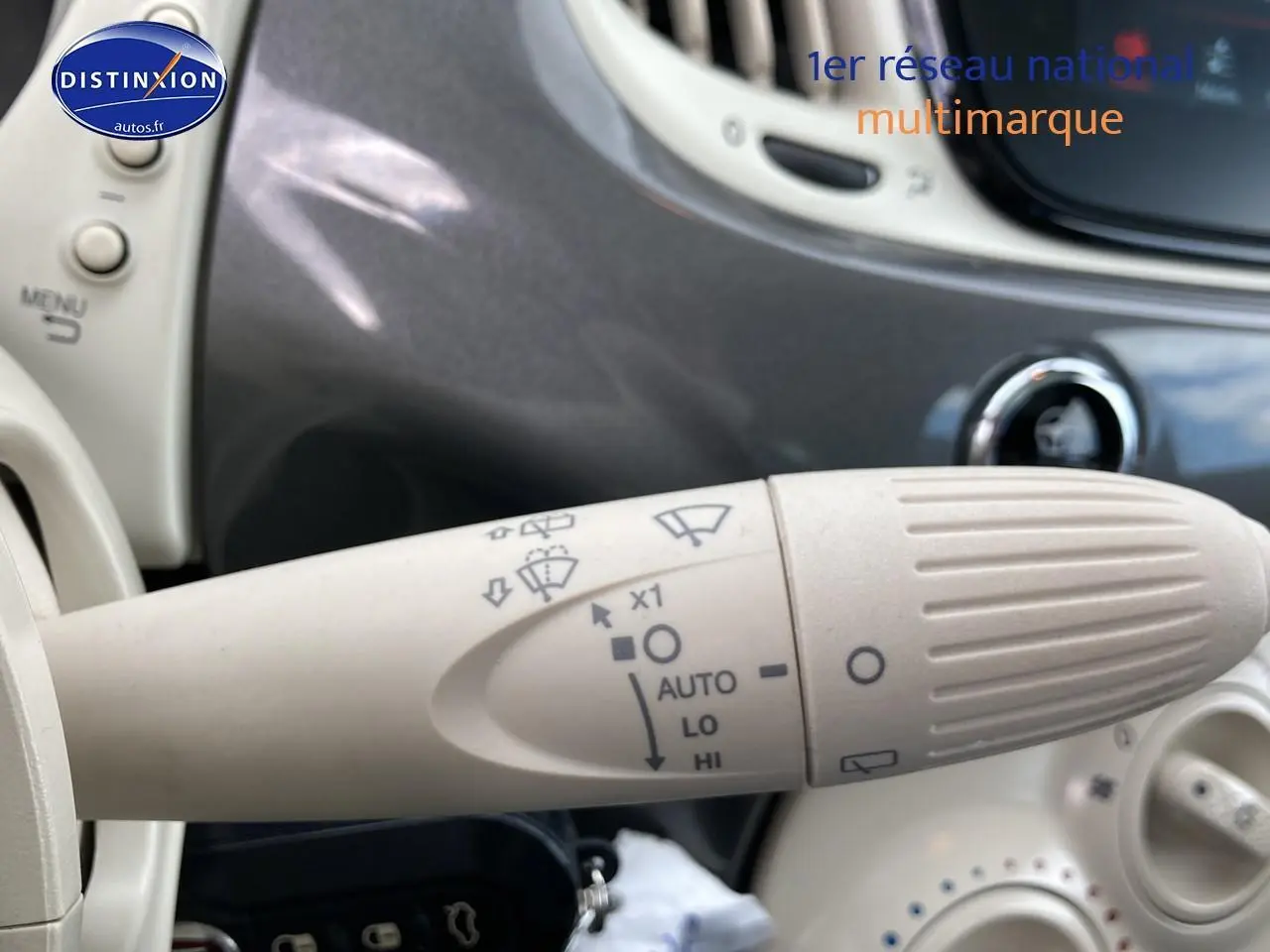 Gros plan sur la commande d’essuie-glace beige à l’intérieur d’une Fiat 500 gris métallisé, version Dolcevita 2022.