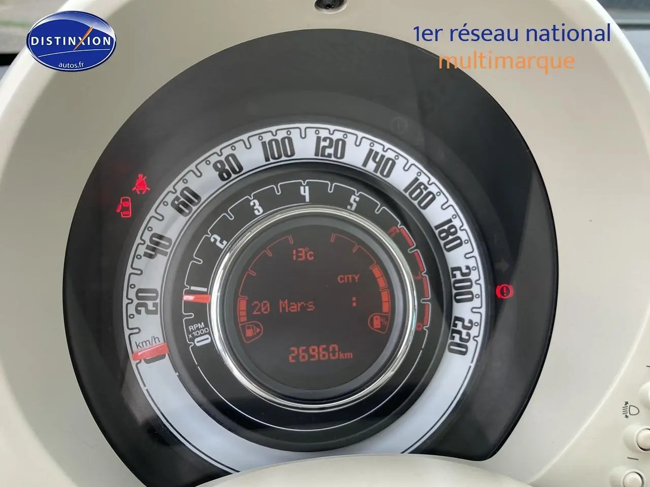 Vue rapprochée du compteur de vitesse circulaire de la Fiat 500 gris, affichant 26960 km et indicateurs numériques rouges.