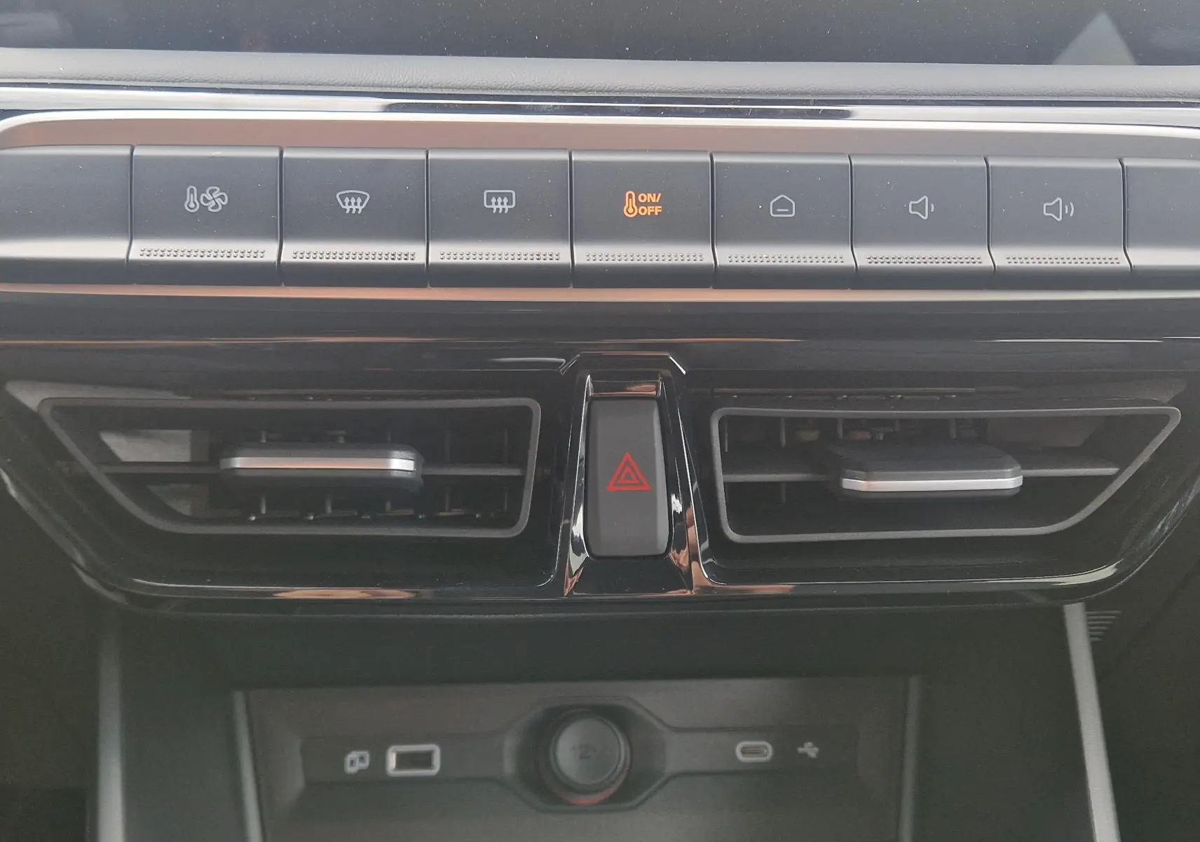 Vue rapprochée de la console centrale du MG3 2026, boutons de climatisation et aérateurs noirs brillants.