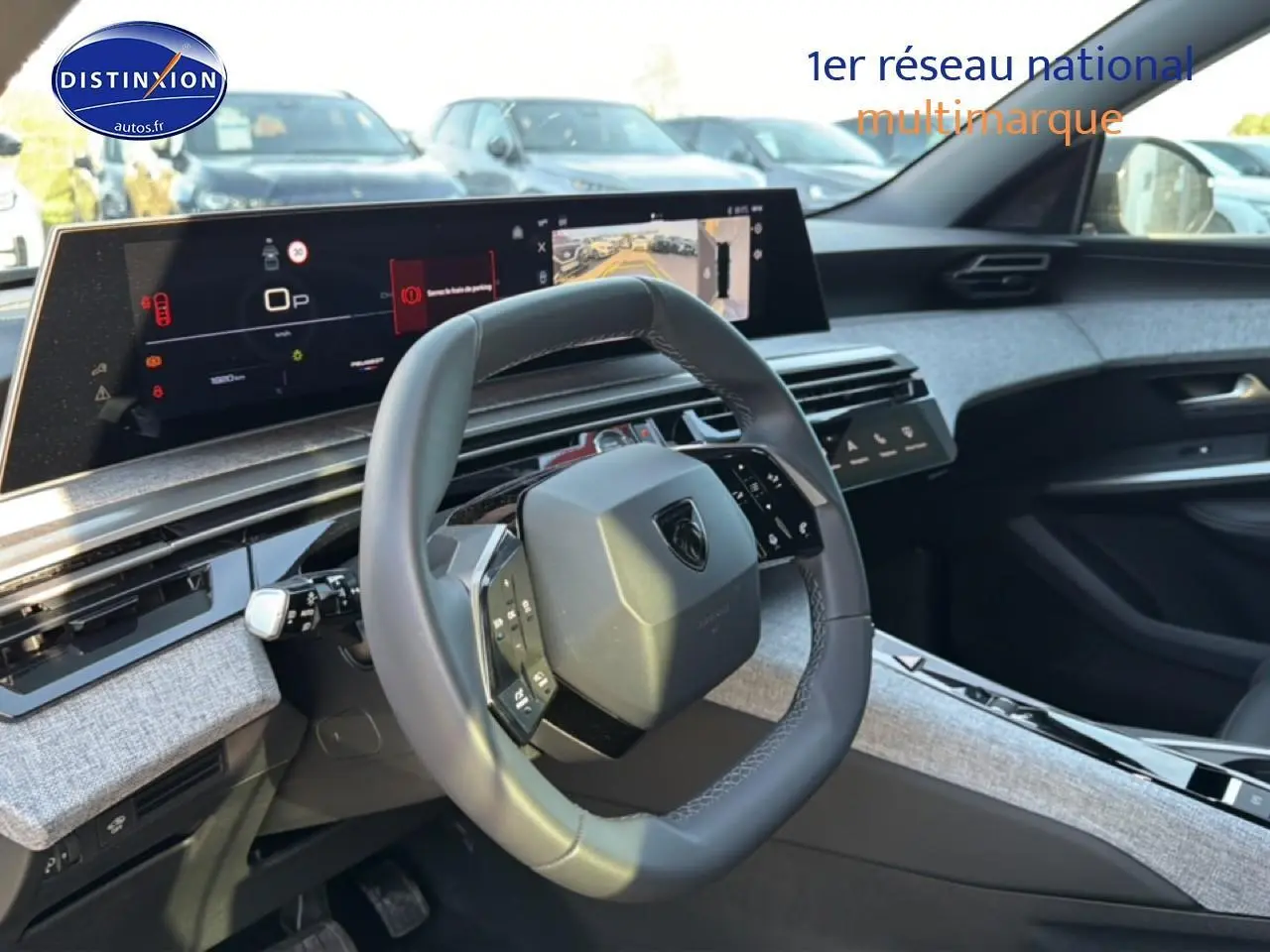 Vue intérieure du poste de conduite du Peugeot 5008 Hybrid 145 allure e-dcs6 avec volant cuir et tableau de bord numérique.