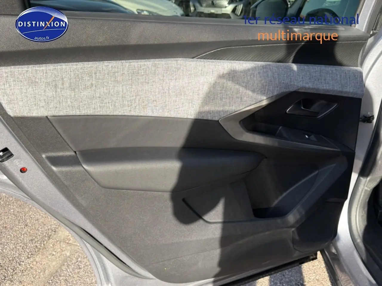 Vue intérieure du panneau de porte avant droit gris avec insert tissu clair du Peugeot 5008 Hybrid 145 allure e-dcs6 2025.