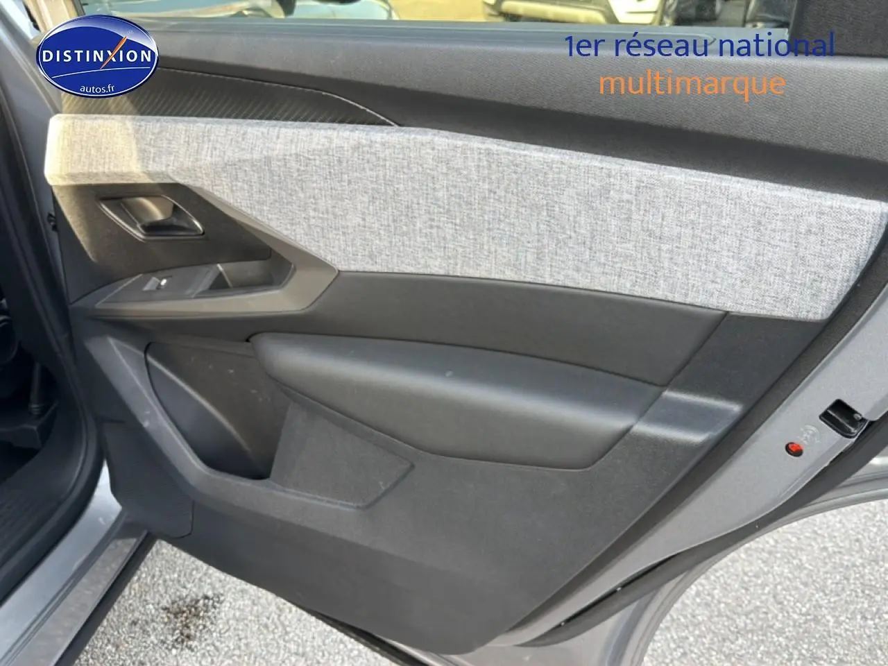 Vue rapprochée de la porte arrière gauche gris artense du Peugeot 5008 Hybrid 145 allure e-dcs6 avec tissu clair et plastique noir.