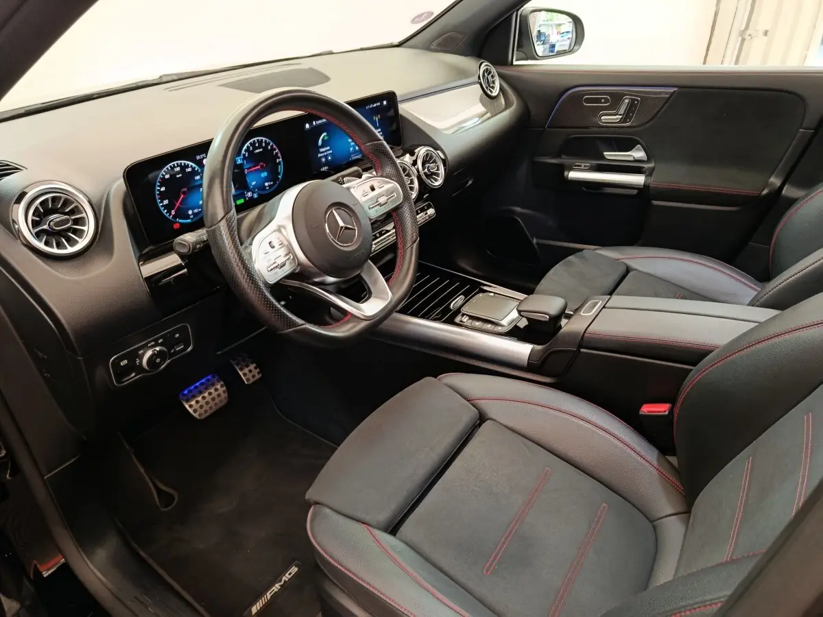 Vue intérieure côté conducteur du Mercedes GLA 250 e AMG Line 2021, sièges noirs avec surpiqûres rouges et tableau de bord digital.