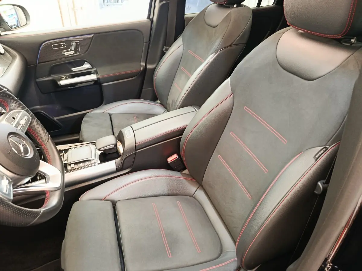 Vue intérieure rapprochée des sièges avant noirs avec surpiqûres rouges du Mercedes GLA 250 e AMG Line 2021.