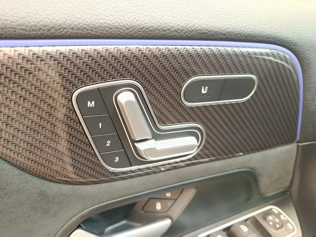 Détail du panneau de porte côté gauche noir avec commandes mémoire siège et bouton de chauffage sur Mercedes GLA 250 e AMG 2021.