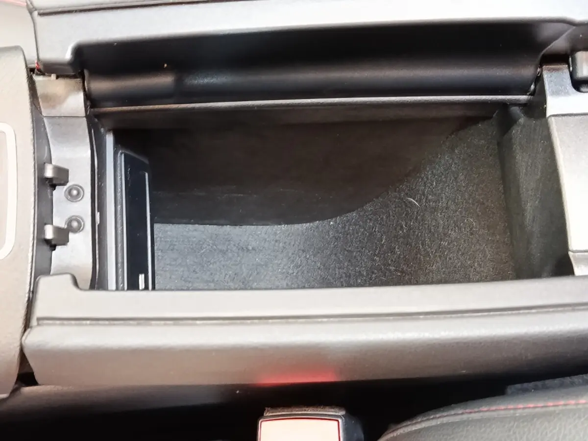 Vue rapprochée de la console centrale ouverte du Mercedes GLA 250 e AMG Line 2021, intérieur noir avec surpiqûres rouges.