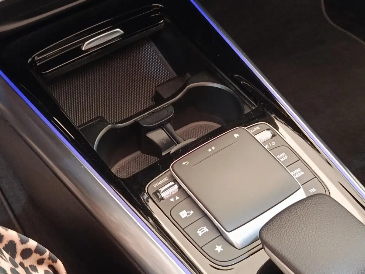 Vue rapprochée de la console centrale noire du Mercedes GLA 250 e AMG Line avec pavé tactile et porte-gobelets.