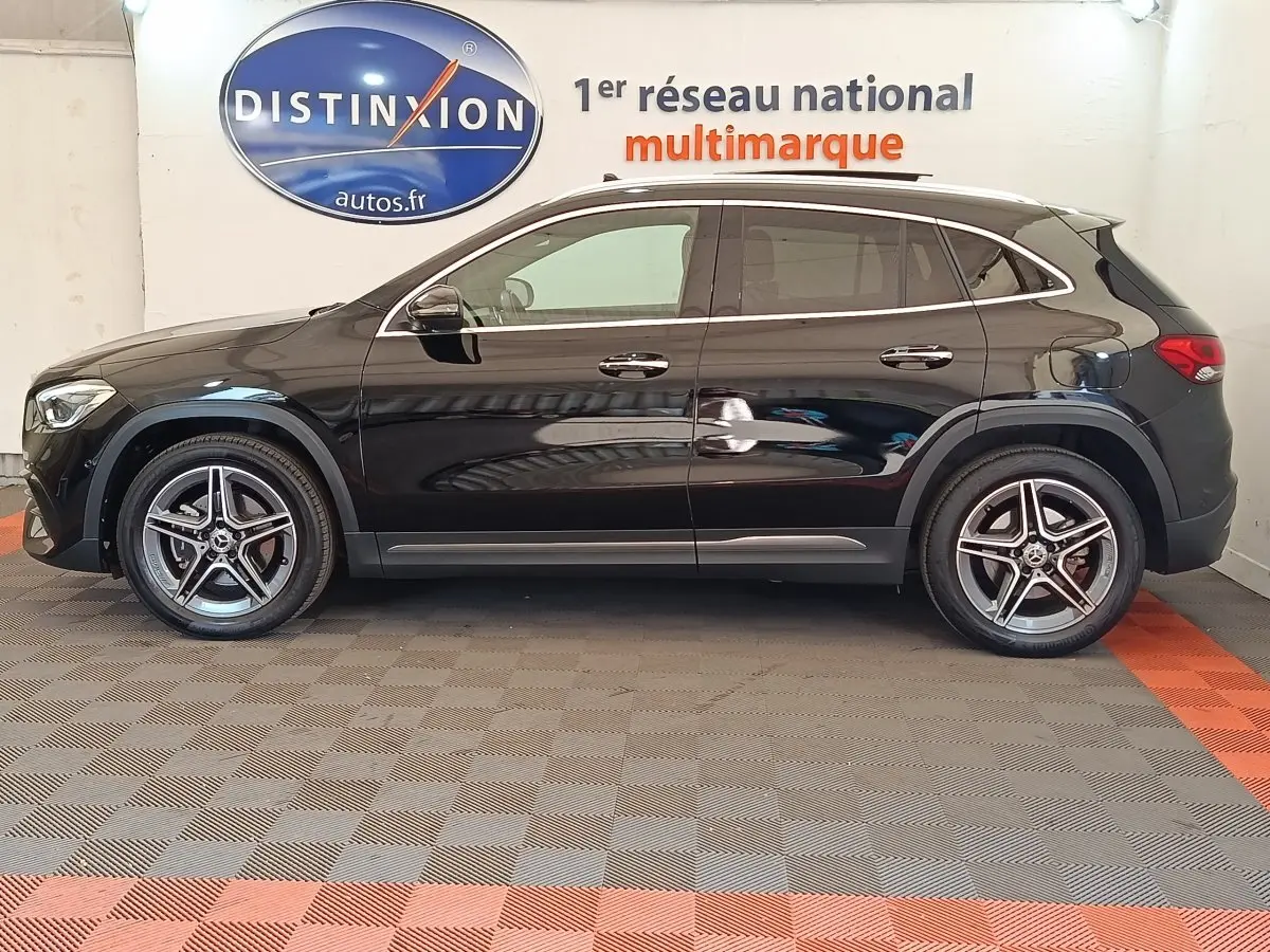 Vue latérale gauche d’un Mercedes GLA 250 e AMG Line noir, avec jantes alliage et toit panoramique visible.