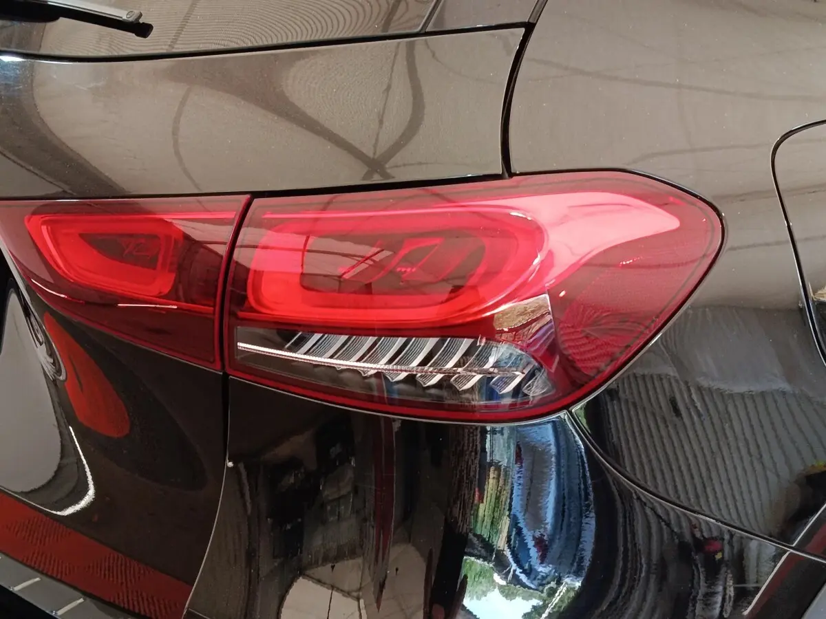 Gros plan sur le feu arrière droit rouge d’un Mercedes GLA 250 e AMG Line noir, vue arrière latérale.