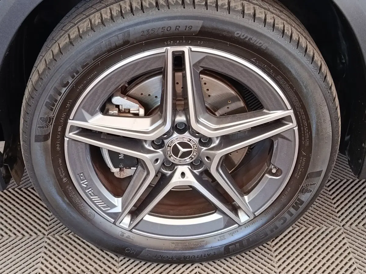 Gros plan sur la jante AMG étoile en alliage gris foncé du côté gauche d’un Mercedes GLA noir hybride rechargeable.