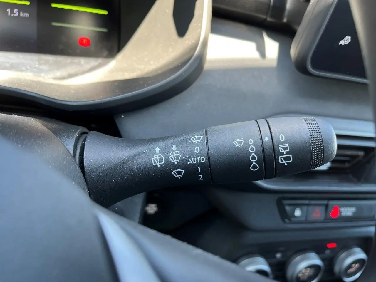 Gros plan sur la commande des essuie-glaces du tableau de bord du Dacia Jogger 1.6 Hybrid 2025, intérieur noir.