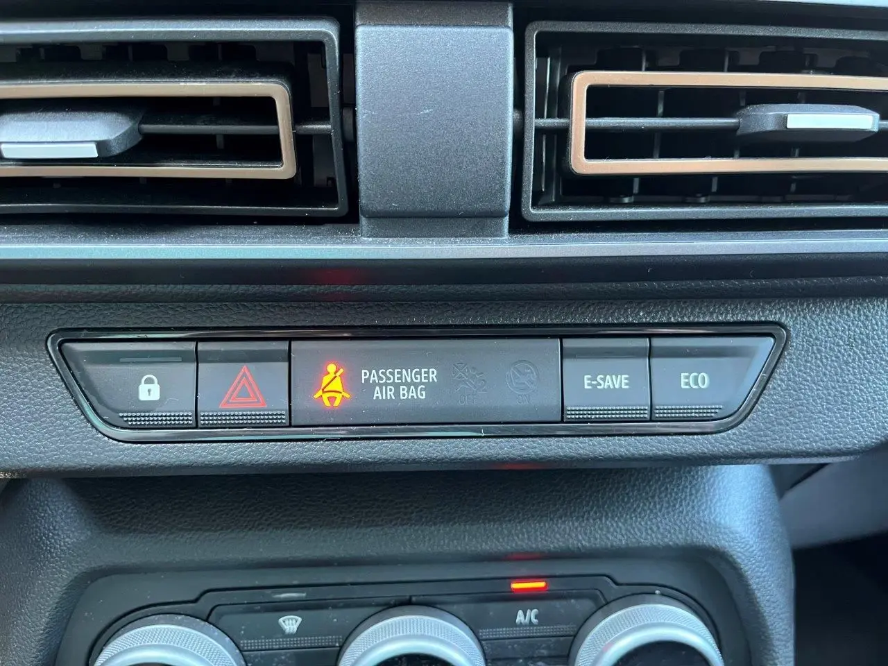 Gros plan sur la console centrale du Dacia Jogger 2025, montrant les boutons de sécurité et climatisation.