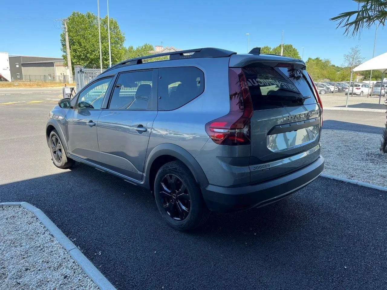 Vue 3/4 arrière droite du Dacia Jogger gris schiste 2025 avec jantes noires et feux arrière verticaux distinctifs.