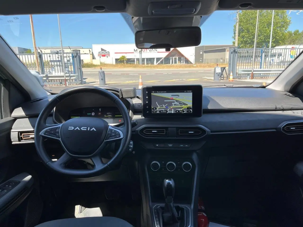 Vue intérieure frontale du tableau de bord du Dacia Jogger 2025 avec écran tactile GPS et volant multifonction noir.