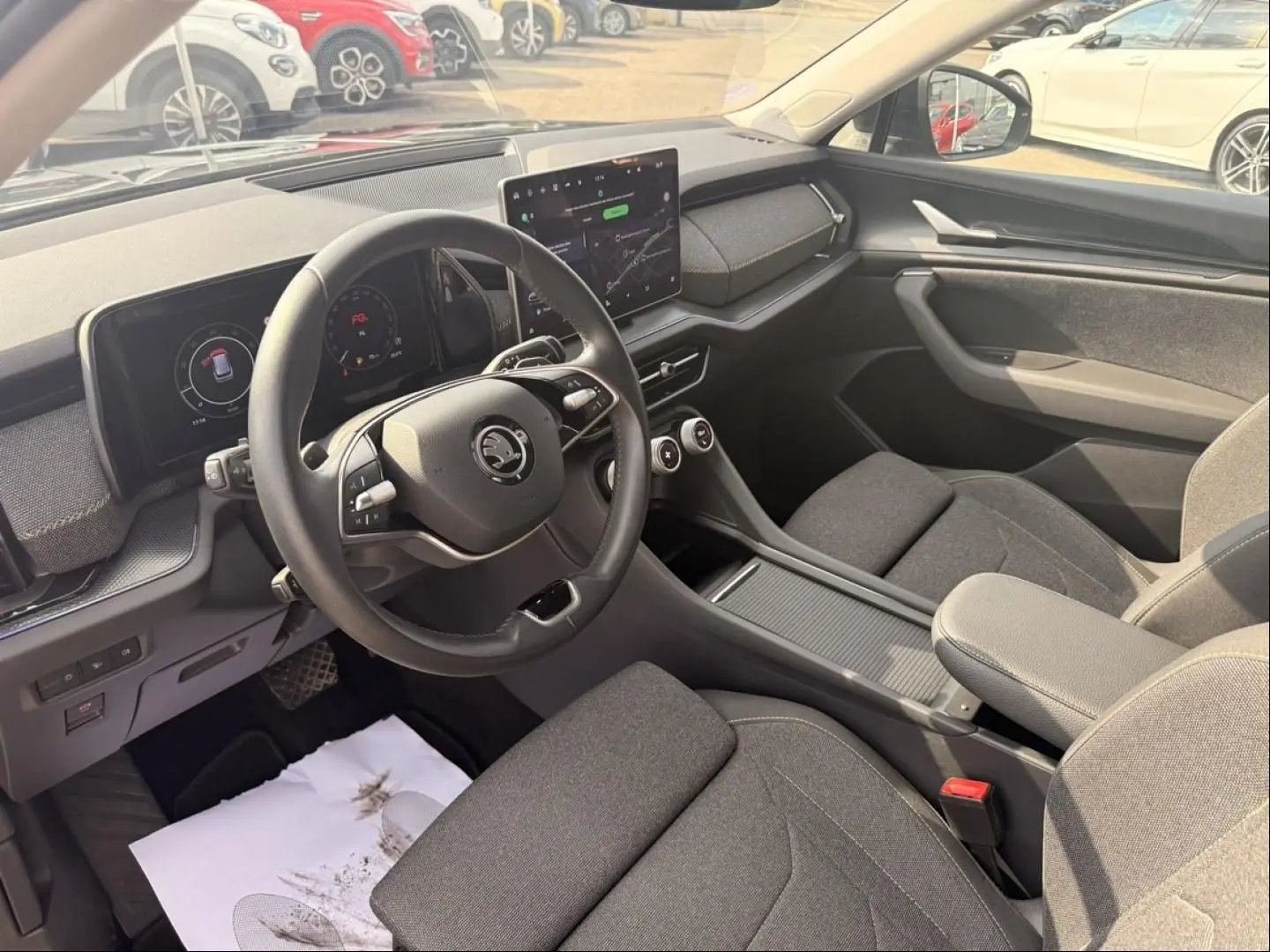 Vue intérieure côté conducteur du Skoda Kodiaq 2024 noir, montrant le volant, tableau de bord numérique et écran central tactile.