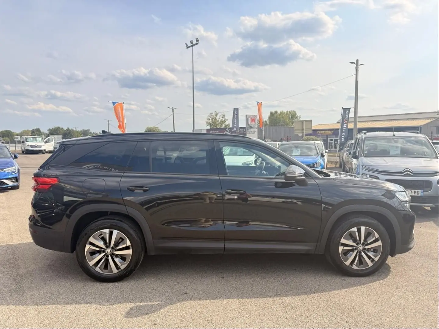 Vue de profil côté gauche d’un Skoda Kodiaq noir 2024, SUV 7 places avec jantes alliage et vitres teintées.