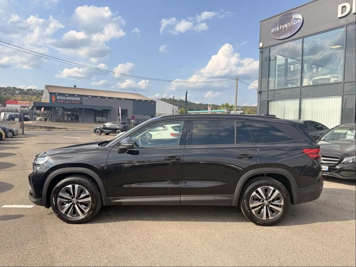 Vue de profil côté gauche d’un Skoda Kodiaq noir 2024, SUV 7 places avec jantes alliage distinctives.