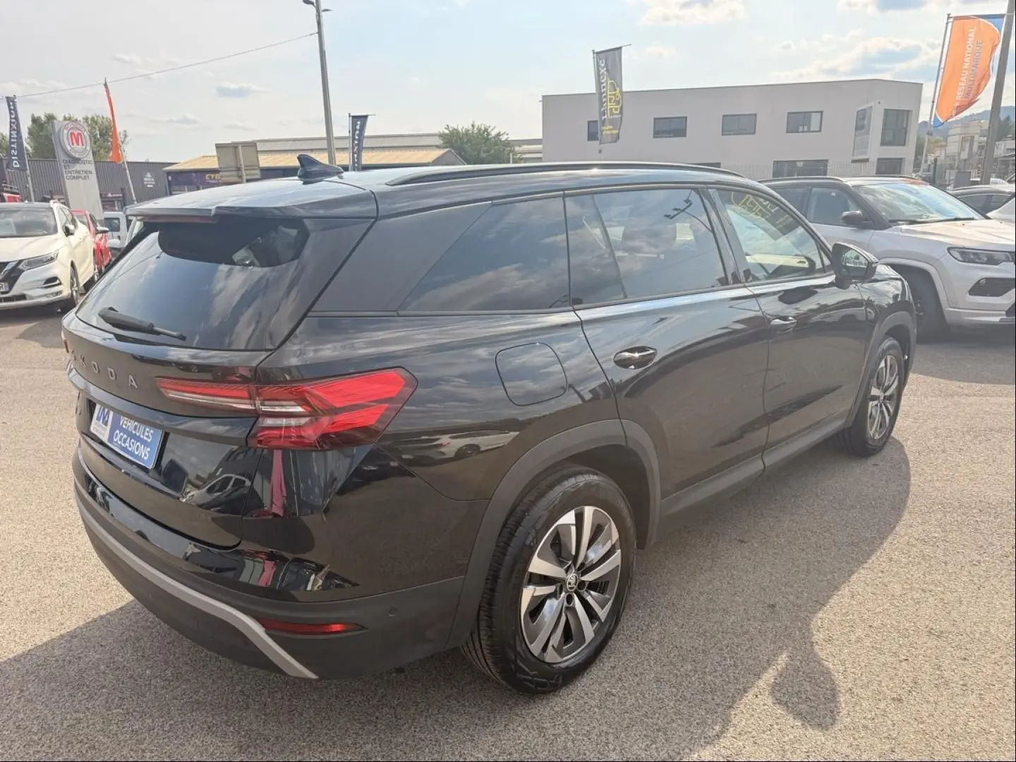 Vue 3/4 arrière droite du Skoda Kodiaq noir 2024 avec feux arrière LED et jantes alliage, stationné en extérieur.