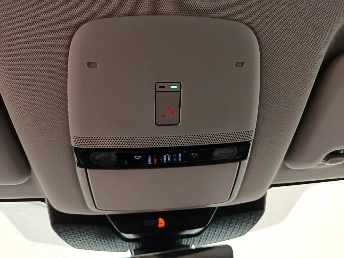 Vue en contre-plongée du plafonnier beige avec bouton SOS et éclairages intégrés du Nissan Ariya noir 2026.