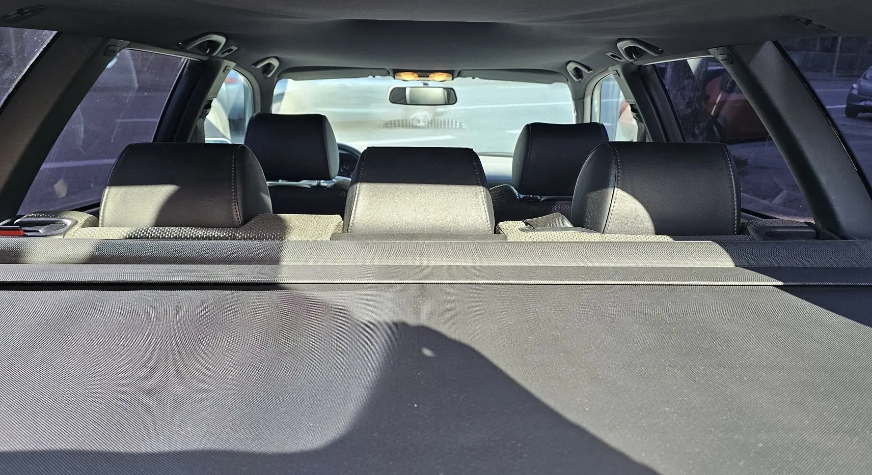 Vue arrière intérieure de l'Audi RS4 Avant grise de 2001, montrant les appuie-têtes noirs et la plage arrière.