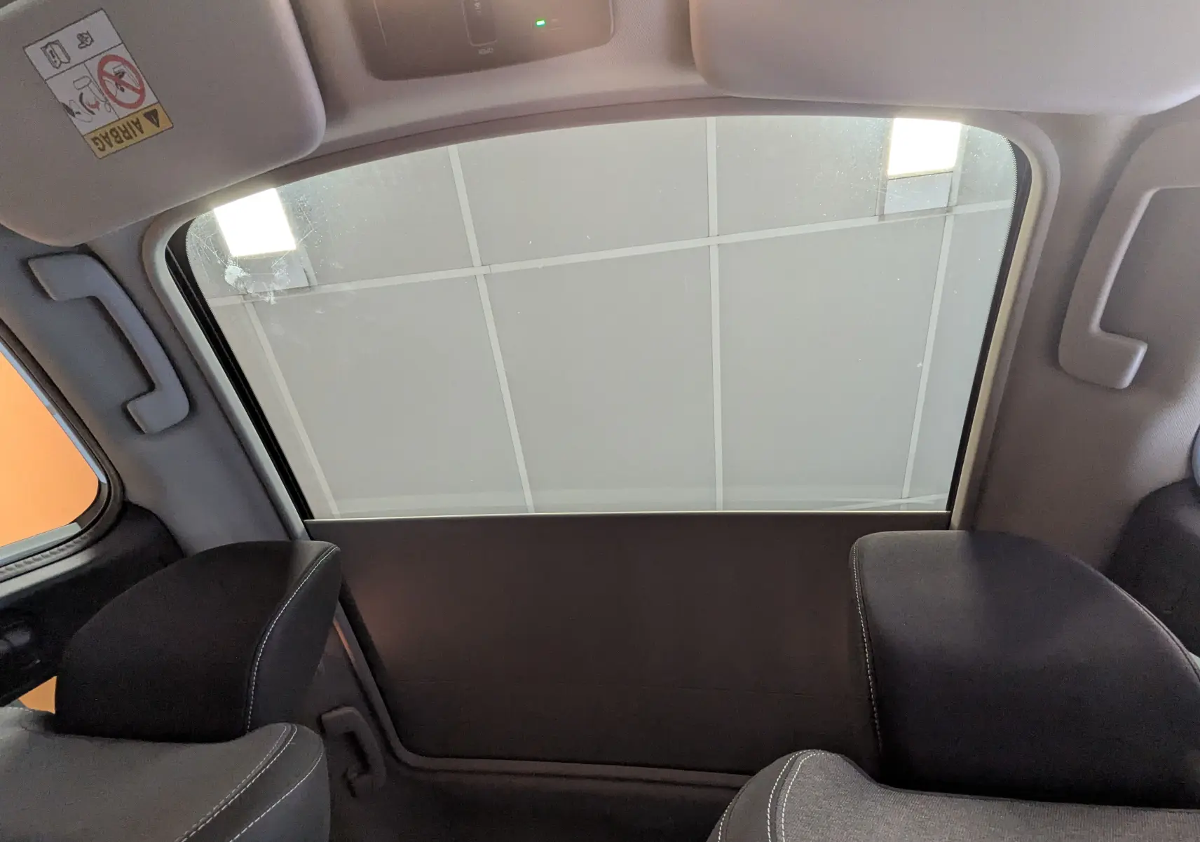 Vue intérieure arrière côté gauche du Nissan Qashqai 2024 blanc, montrant la fenêtre latérale et les appuie-têtes noirs.