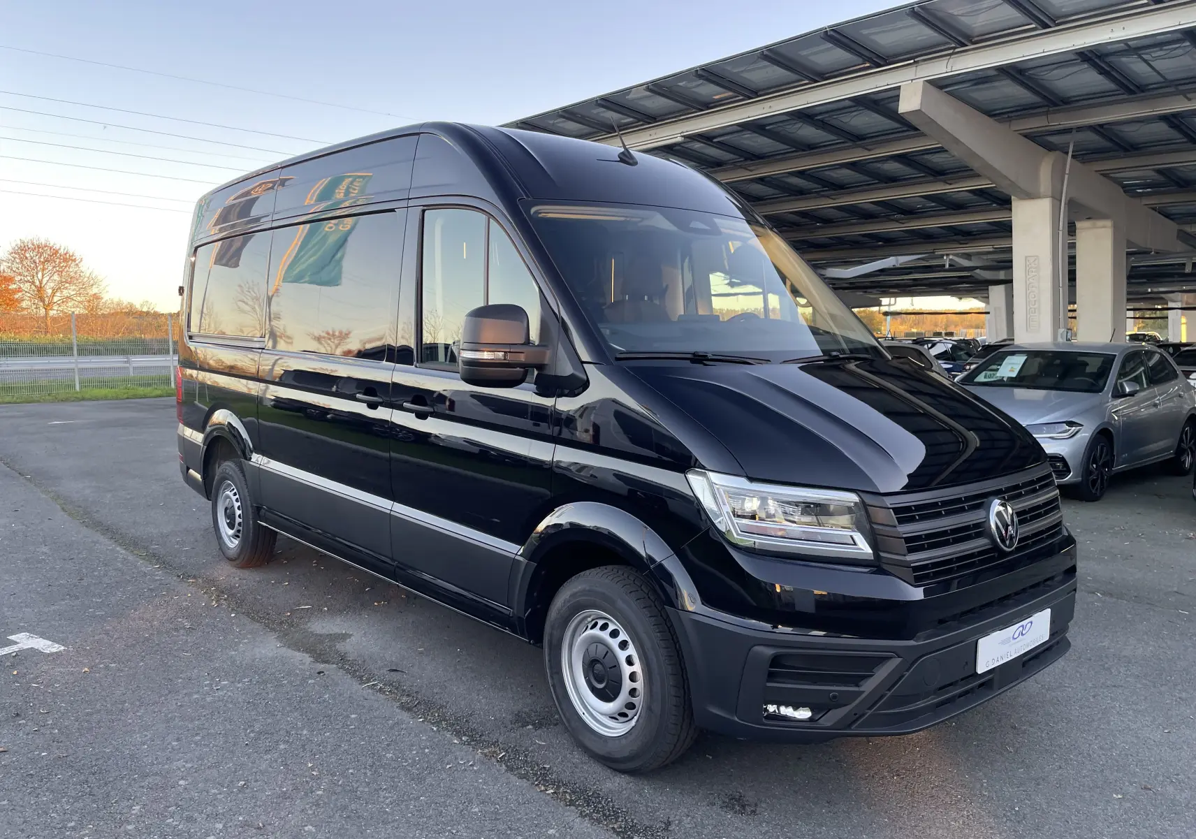 Vue 3/4 avant droit d'un Volkswagen Crafter Van noir intense 2025 avec phares LED et carrosserie haute.